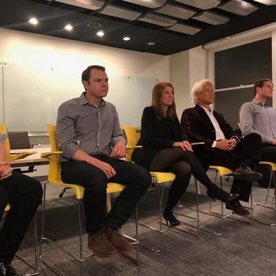 Four panelists seated in yellow chairs listening during a Harvard Alumni in Tech panel